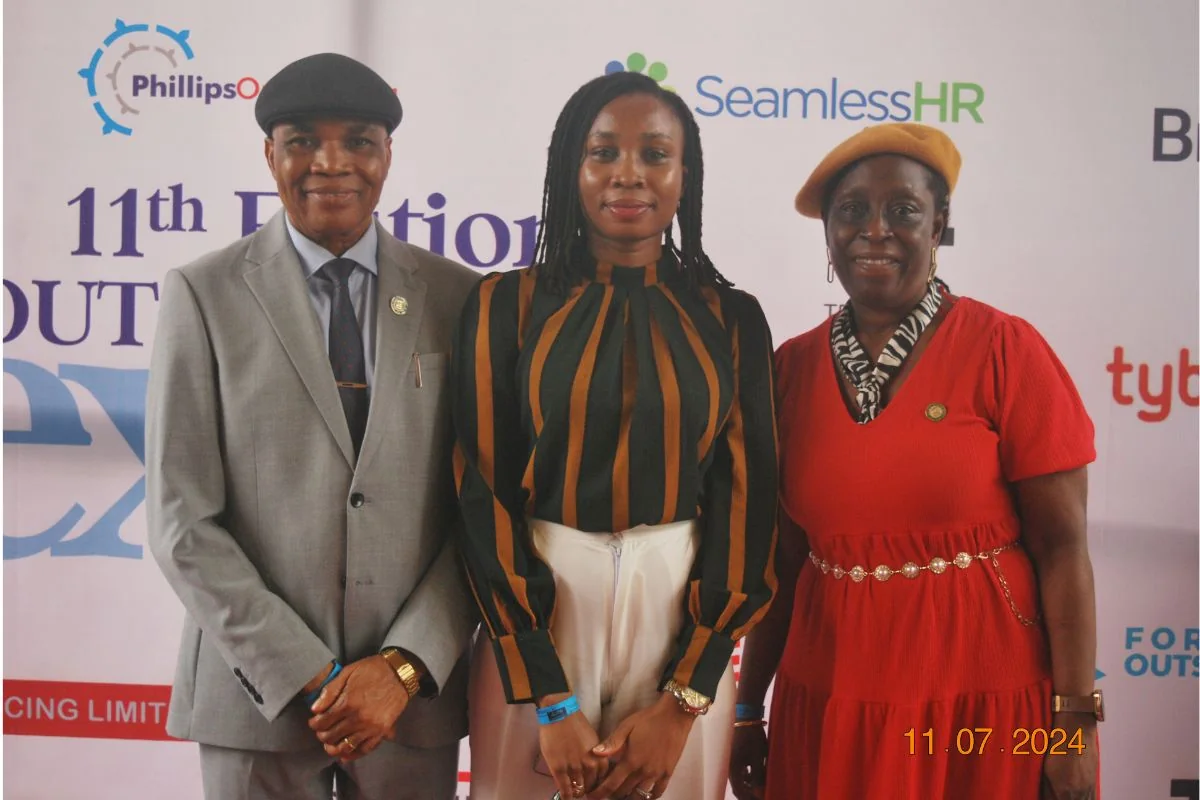 Three Outsourcing Expo 2024 guests photographed at the event backdrop