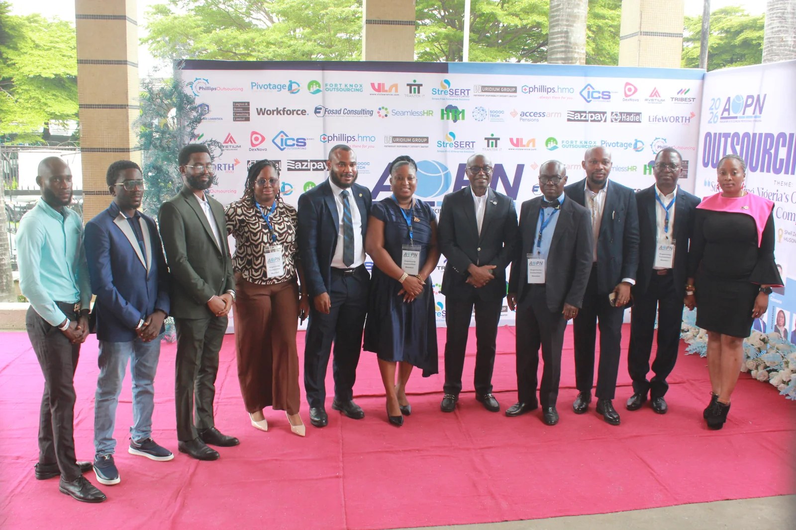 Delegates photographed at the Outsourcing Expo 2026 branded backdrop
