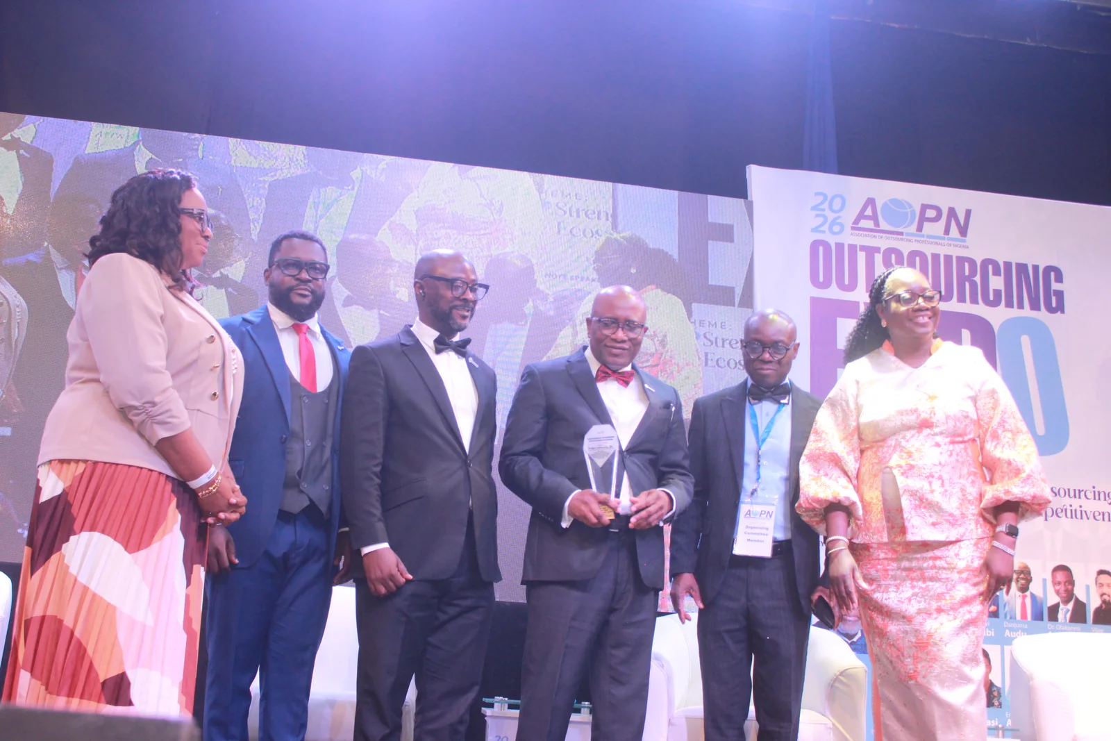 Award recipient with event leaders at Outsourcing Expo 2026